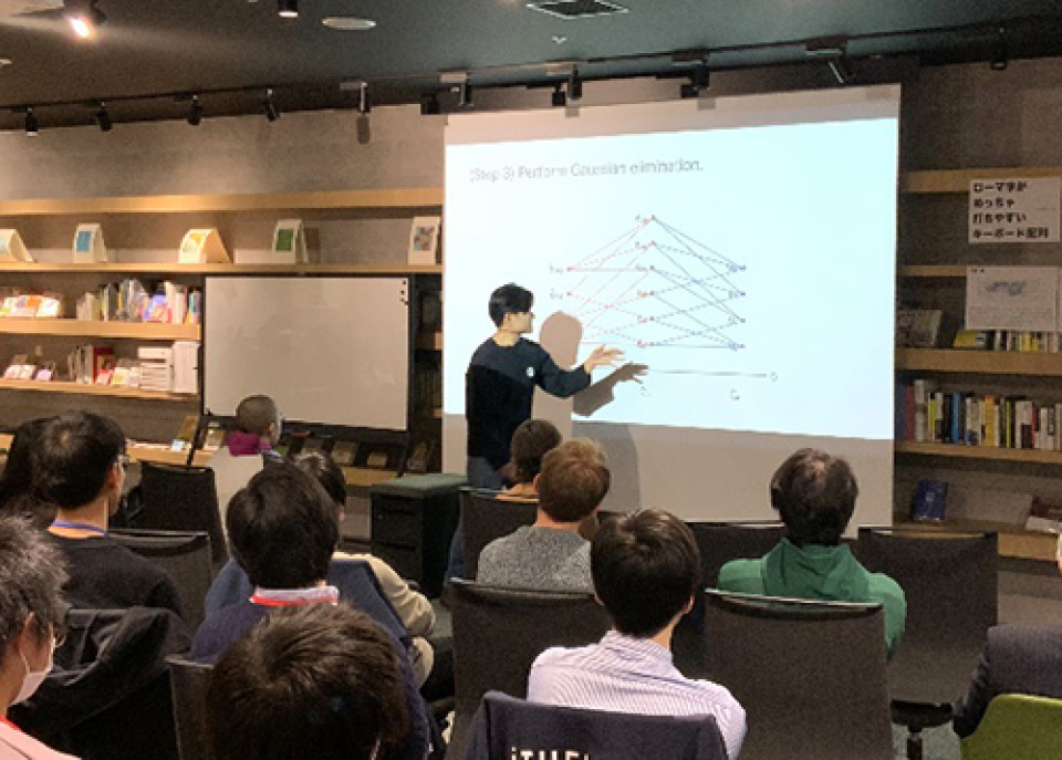 Photo of Taketo Sano (iTHEMS Special Postdoctoral Researcher) giving presentation